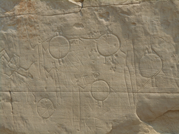 petroglyph, stick figures with large circular shields in front of them depicting a Battle scene carved in sandstone