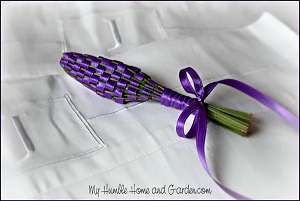 a wand of woven lavender and purple ribbon on a white background 