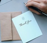 A person writing on a thank you card 